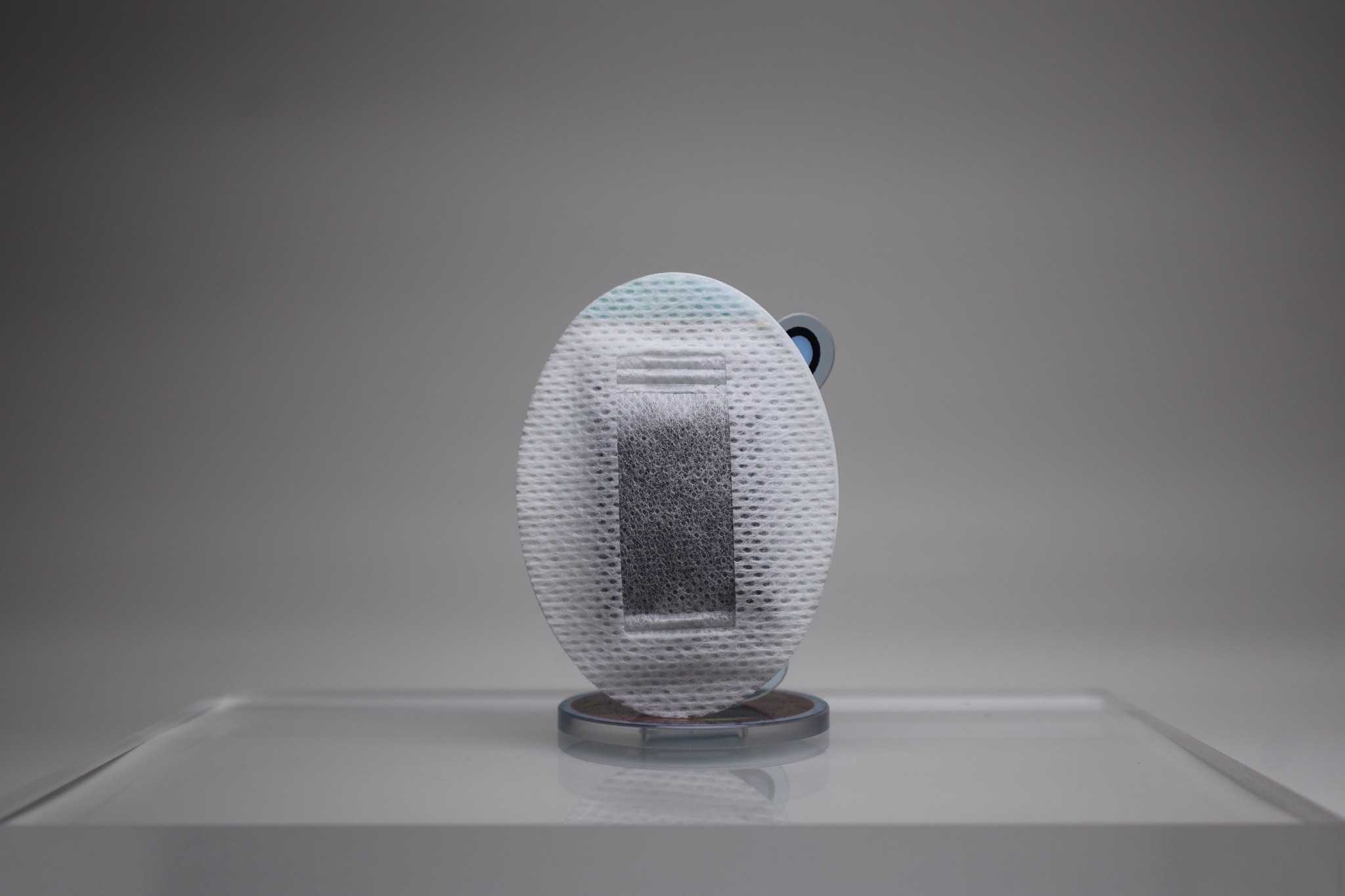 Real product photograph showing the fabric texture of the filtration pouch and the darker material contained inside.