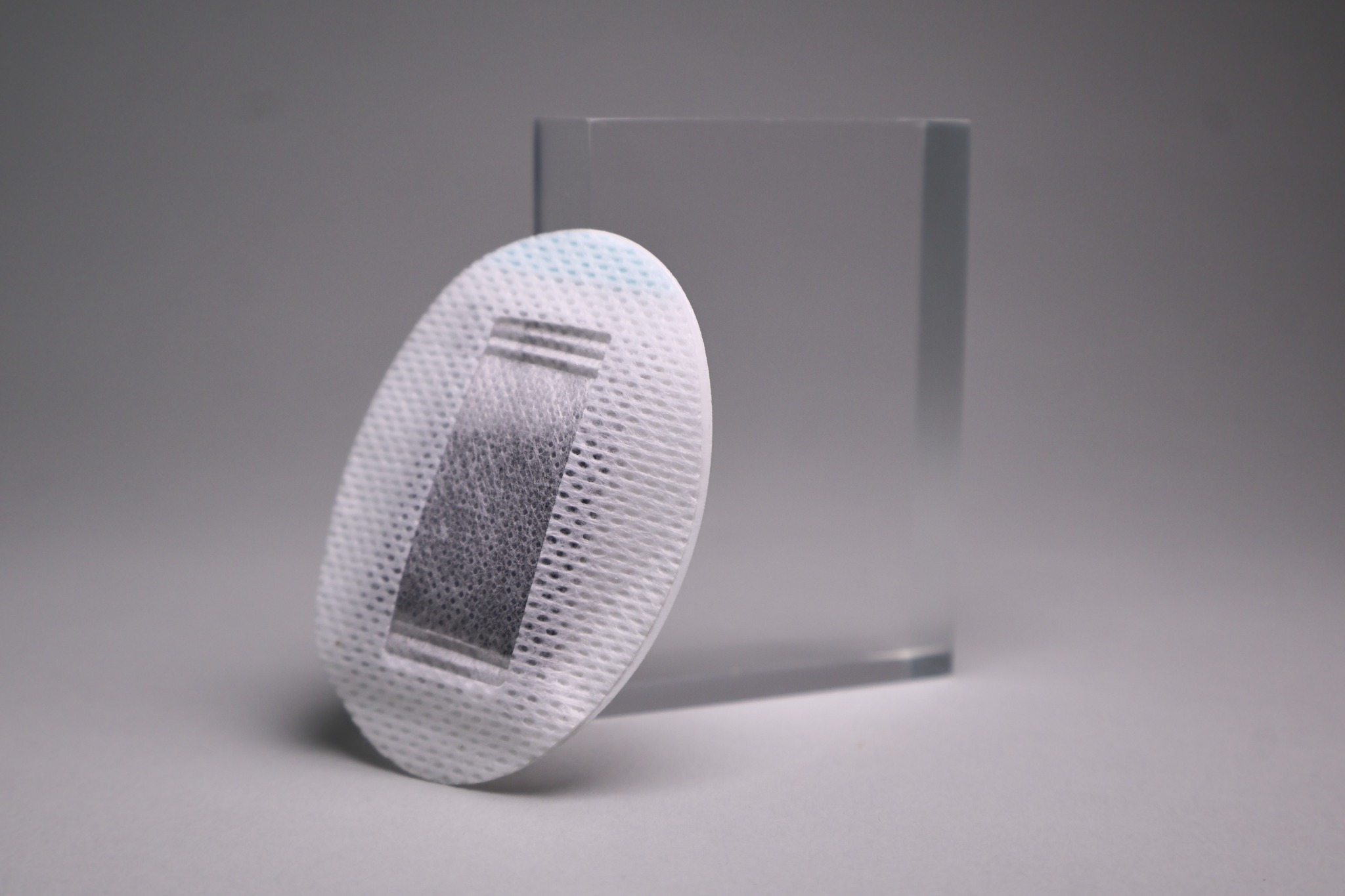 Angled studio view of the compact patch with a transparent acrylic block.
