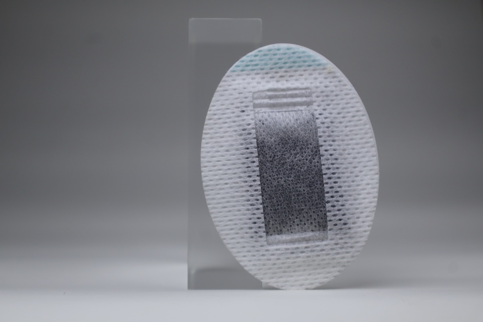 A softly lit front view of the fabric carrier and central filtration pouch.